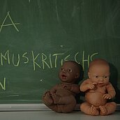 Schultafel mit 2 Puppen mit unterschiedlicher Hautfarbe